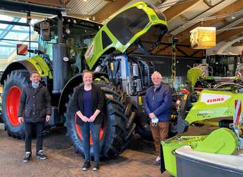 3 Personen vor einer CLAAS-Landmaschine