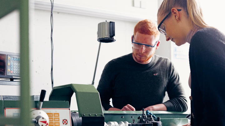 Zwei Studierende experimentieren an einer Maschine