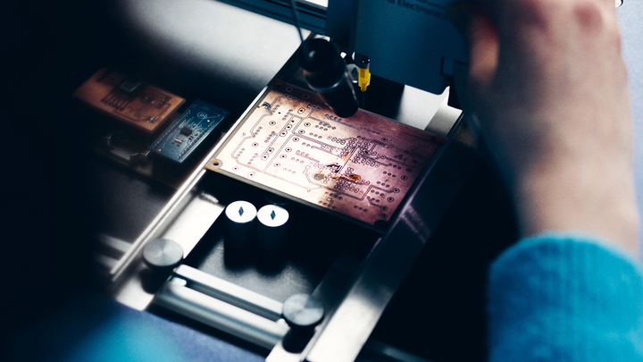 Eine Studentin untersucht eine Platine